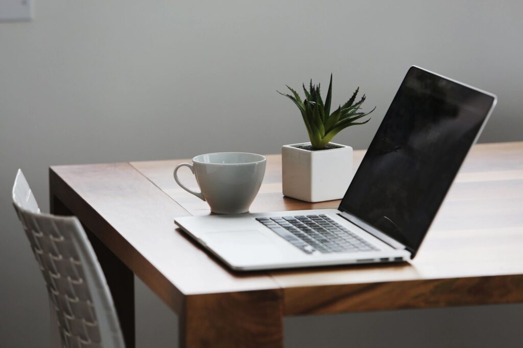 Picture of a laptop and mug on a table. The perfect tools for signing up to join South Manchester Swifts community group.